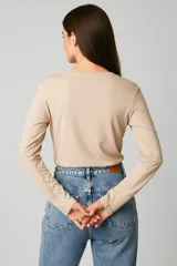 Remera de manga larga, color negro, con cuello redondo y un bolsillo de parche en el pecho.