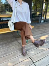 Camisa de corte clásico con estampado de rayas verticales en tonos beige y blanco, cuello camisero, cierre frontal de botones y mangas largas con puños vueltos.