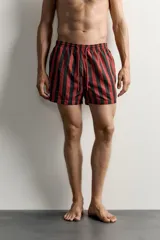 Short de baño confeccionado en tejido técnico, con diseño de rayas verticales en color verde y negro. Cuenta con cintura elástica ajustable con cordón, bolsillos laterales y bolsillo trasero con vivo, además de forro interior.