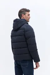 Campera puffer con capucha integrada, cierre frontal cubierto y bolsillos laterales. Confeccionada en nylon, presenta un diseño acolchado y funcional ideal para climas fríos.
