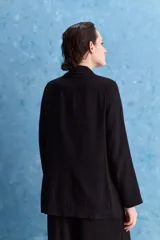 Blazer negro de corte relajado, con solapa clásica y cierre frontal.