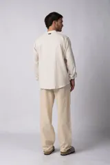 Camisa de manga larga confeccionada en lino, con cuello mao y cierre frontal de botones. Presenta un corte relajado y diseño minimalista.