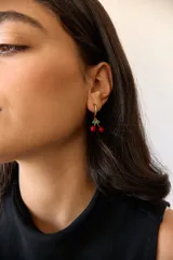 Aros de acero quirúrgico hipoalergénico, con argolla pequeña y dije colgante en forma de cerezas.