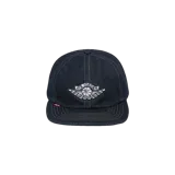 Gorro de mezclilla Nike Jordan x Levi's en color azul oscuro, con visera plana y bordado frontal del logo Air Jordan Wings. Incluye costuras en contraste y una etiqueta roja lateral inspirada en Levi's.