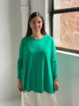 Sweater de punto color verde, con cuello redondo, mangas largas con puños acanalados y diseño holgado con detalle de costura vertical central.