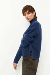 Polera de tejido de punto color bordó, con cuello alto, manga larga y costura vertical central en el frente.