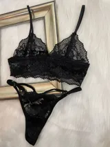 Conjunto de lencería de encaje negro compuesto por un top estilo bralette y una tanga colaless regulable. El top presenta breteles ajustables y diseño sin broches, confeccionado en encaje suave y elastizado.