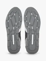 Zapatillas tipo runner de Tommy Hilfiger en tonos gris y gris oscuro, con detalles en blanco. Confeccionadas en una mezcla de cuero y textil, cuentan con pasadores blancos, suela de goma blanca y diseño lateral característico de la marca.