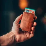 Billetera tipo tarjetero de cuero negro con caja de aluminio interna y sistema de deslizamiento para tarjetas. Cuenta con cierre mediante broche a presión.