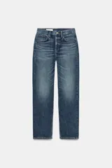 Jeans de tiro medio con corte straight, color azul con efecto lavado y roturas sutiles, cinco bolsillos y cierre frontal con cremallera y botón metálico.