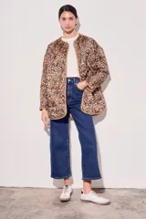 Campera color camel con diseño acolchado, cierre con botones a presión, cuello de piel sintética desmontable, bolsillos delanteros y puños ajustables con lazo.