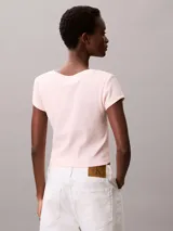Remera de Calvin Klein confeccionada en algodón elástico con textura de canalé fino. Presenta un diseño de corte slim, cuello en V, manga corta y una insignia con el logo de la marca en el pecho.