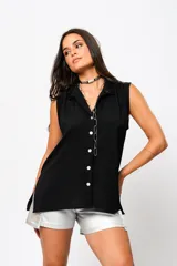 Camisa negra sin mangas con cuello mao adornado con un delicado volado y cierre frontal con botones.