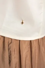 Musculosa negra de satén con escote en V, tirantes finos y detalle de volados en el pecho.