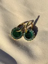 Aros de acero quirúrgico con dije circular de resina rosa y borde de strass dorados.