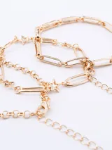 Set de tres pulseras doradas con diferentes diseños de cadenas y dijes de estrellas.