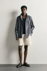 Camisa de corte regular fit confeccionada en tejido de algodón, con cuello solapa, manga larga con puños abotonados, bolsillo plastrón en el pecho y cierre frontal de botones.