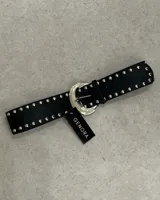 Cinturón negro de cuero sintético con hebilla plateada y tachas plateadas.