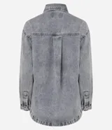 Camisa de corte oversized confeccionada en denim de algodón con lavado gris desgastado. Presenta cuello clásico, cierre frontal con botones metálicos, manga larga con puños abotonados y un bolsillo aplicado en el pecho. El diseño incluye un bajo redondeado.