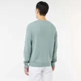 Sweater de punto con textura fantasía, cuello redondo y mangas largas con puños acanalados.