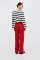 Pantalón en lona de algodón con cintura de tiro alto y cierre con botones. Piernas rectas con raya adelante y atrás, y bolsillos atrás de parche.