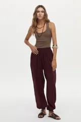 Pantalón babucha bordó con elástico en la cintura trasera y bolsillos laterales, de corte amplio y fluido.