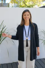 Saco abierto de punto color negro, con mangas largas y bolsillos frontales. Diseño de corte recto y largo medio.