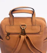 Mochila de diseño versátil en color marrón, confeccionada con una combinación de texturas en cuero sintético. Presenta un compartimento principal con cierre, un bolsillo frontal amplio con cierre y bolsillos laterales abiertos. Incluye manijas superiores fijas y una correa larga extraíble y ajustable para usar como bolso o mochila.