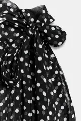 Top de cuello halter con hombros descubiertos, confeccionado con una combinación de tejidos. La parte superior presenta un estampado de lunares, mientras que la parte inferior es de tejido liso acanalado.