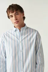 Camisa celeste a rayas verticales blancas, de corte slim fit, manga larga y logo bordado en el pecho.