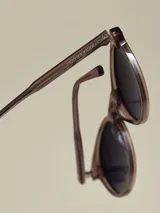 Anteojos de sol con armazón negro mate y forma redonda. Lentes con filtro degradado oscuro.