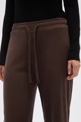 Pantalon de corte holgado y tiro alto, confeccionado en tejido de poliester con textura acanalada. Presenta cintura elástica con cordón de ajuste y diseño de pierna ancha.