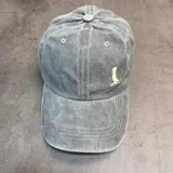 Gorra tipo baseball de jean color gris, con logo bordado en blanco en el frente y cierre ajustable en la parte posterior.