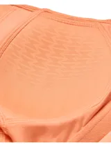 Top deportivo Under Armour modelo SmartForm Evoluti color salmón, con escote en V y diseño de tirantes cruzados en la espalda.