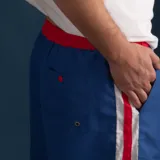Short de baño azul con cintura elástica roja y rayas verticales blancas y rojas.