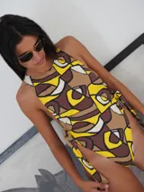 Malla enteriza con estampado geométrico en tonos amarillo, marrón y beige, de cuello redondo y lazos laterales removibles.
