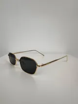 Lentes de sol con armazón metálico dorado y cristales oscuros de forma rectangular con bordes redondeados. Cuentan con protección UV400.