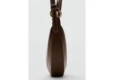 Bolso tipo hobo de tamaño pequeño, color marrón, con diseño ovalado tipo medialuna, asa corta y herrajes metálicos dorados. Cuenta con cierre de cremallera superior y textura granulada.