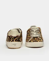 Zapatillas bajas con estampado animal print, cordones con letras estampadas, suela de goma color crema y refuerzo de cuero en el talón.
