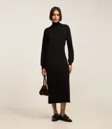 Vestido de punto negro, de manga larga y cuello alto, con corte recto y largo midi.