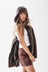 Campera estilo biker de cuero genuino en color marrón, con diseño oversize, cierre frontal metálico y bolsillos laterales con cierre.
