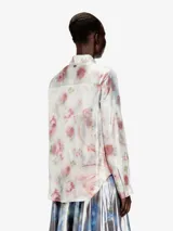 Camisa Diesel C-Ronor-S2 de mujer, manga larga, confeccionada en tejido fluido y semitransparente con acabado metalizado y estampado abstracto de efecto acuarela en tonos azules, plateados y blancos. Presenta cuello clásico y cierre frontal de botones.