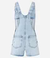 Peto corto de jeans marmorizado celeste, con tirantes ajustables, bolsillo tipo canguro y cierre lateral con botones.