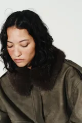 Cazadora de efecto ante con cuello de solapa y aplicación de pelo sintético desmontable. Presenta manga larga, trabillas en los hombros, bolsillos frontales con solapa y cierre de cremallera con botones ocultos.