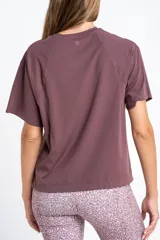 Remera de fitness color bordó, de corte holgado, cuello redondo y mangas cortas. Confeccionada en tejido técnico de secado rápido.
