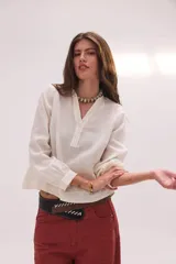 Blusa de lino color marrón con cuello mao, escote en V y mangas largas.
