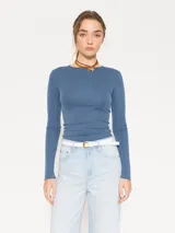 Remera de punto con textura acanalada, manga larga y escote redondo. Presenta un diseño ajustado al cuerpo con espalda abierta.