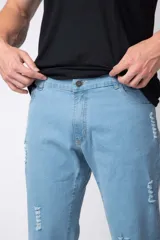 Jean de corte recto y calce relajado, confeccionado en denim de tono azul claro con detalles de roturas y desgaste.