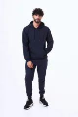 Buzo con capucha y bolsillo frontal tipo canguro, confeccionado en tela de felpa, con cordones ajustables en el cuello y puños elásticos.