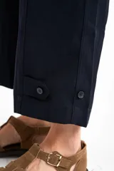 Pantalón ancho azul marino con cintura elástica, bolsillos laterales y detalle de botones en el tobillo.
